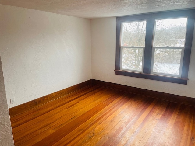 empty room featuring a textured ceiling and dark hardwood / wood-style floors