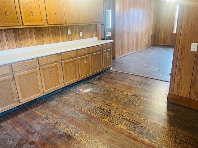 kitchen featuring dark hardwood / wood-style floors and wood walls