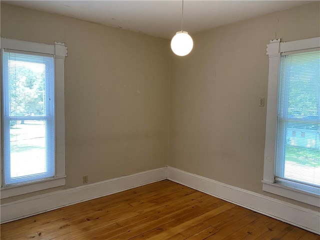 902 1st St, Charleston, IL 61920 - empty room with healthy amount of natural light, wood-type flooring, and baseboards
