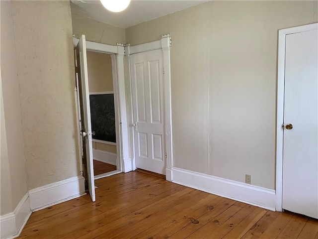 902 1st St, Charleston, IL 61920 - unfurnished bedroom with hardwood / wood-style floors, baseboards, and a closet