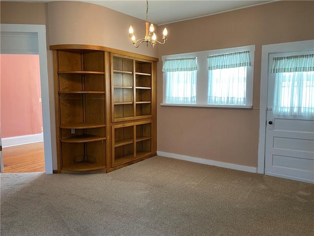 902 1st St, Charleston, IL 61920 - empty room with a chandelier, carpet floors, and baseboards
