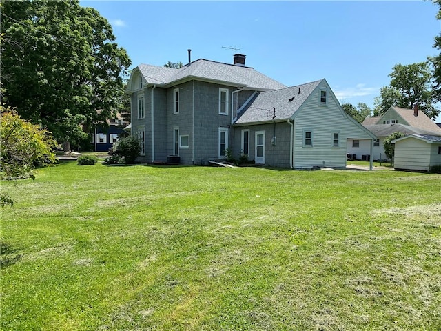 902 1st St, Charleston, IL 61920 - back of house with a chimney, a lawn, and roof with shingles