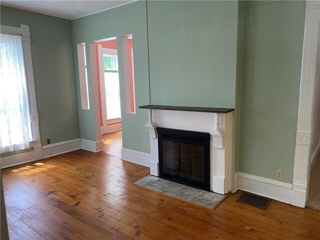 902 1st St, Charleston, IL 61920 - unfurnished living room with hardwood / wood-style flooring, a fireplace with flush hearth, and baseboards