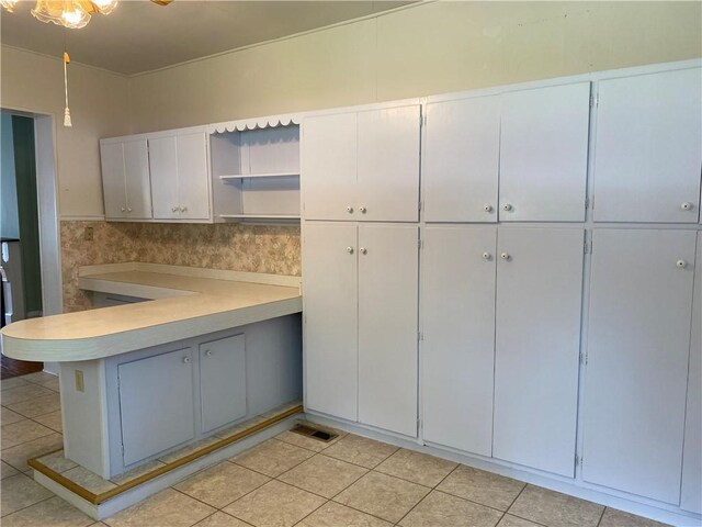 902 1st St, Charleston, IL 61920 - kitchen featuring open shelves, light countertops, light tile patterned flooring, and a peninsula