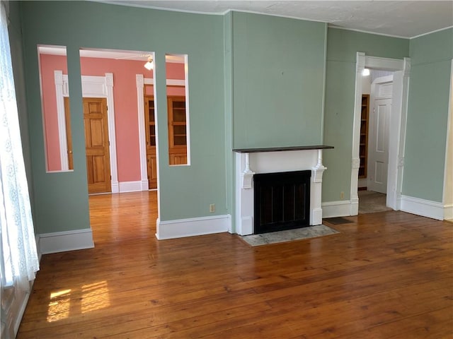 902 1st St, Charleston, IL 61920 - unfurnished living room featuring wood-type flooring, crown molding, a fireplace with flush hearth, and baseboards