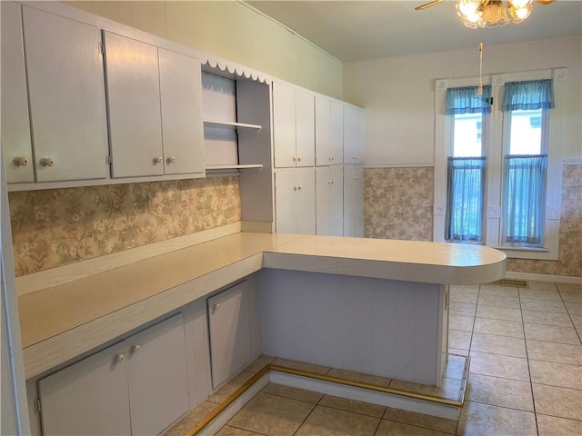 902 1st St, Charleston, IL 61920 - kitchen with open shelves, a peninsula, light countertops, light tile patterned flooring, and white cabinetry