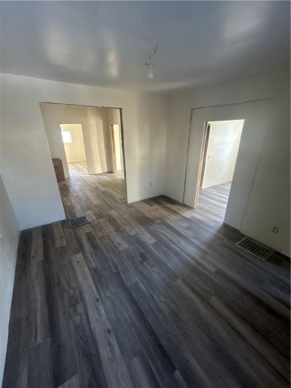 unfurnished room with dark wood-style floors and visible vents