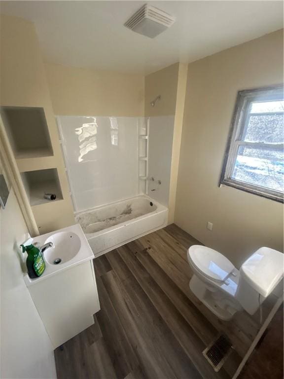 bathroom with visible vents, toilet, wood finished floors, bathtub / shower combination, and vanity