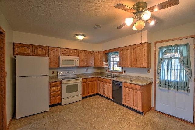 kitchen featuring sink, white appliances, and a textured ceiling