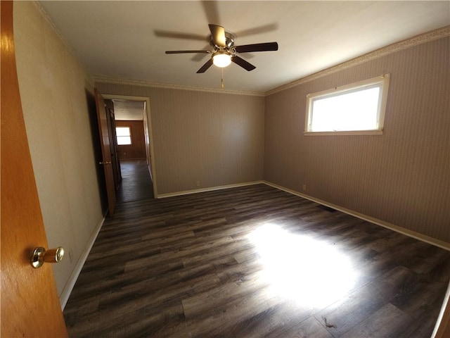 unfurnished room featuring a ceiling fan, dark wood-style flooring, crown molding, and baseboards