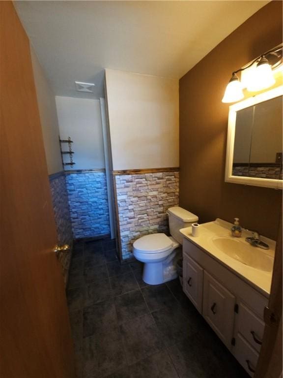 bathroom with visible vents, a wainscoted wall, vanity, and toilet