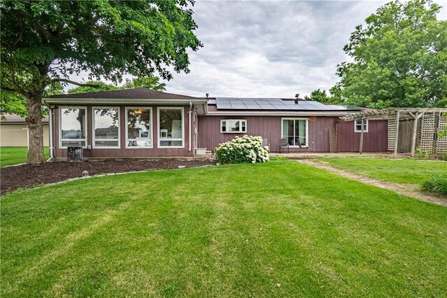 685 E Main St, Warrensburg, IL 62573 - back of property with solar panels, a lawn, and board and batten siding
