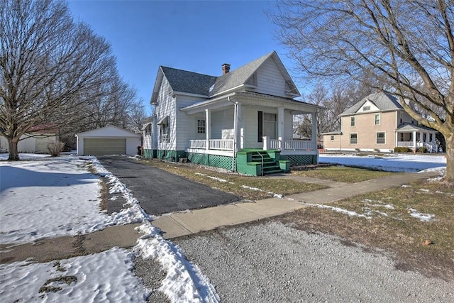 view of front facade with a porch, a garage, and an outbuilding