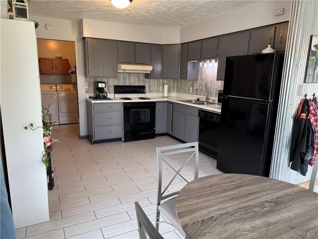 102 W Adams St, Toledo, IL 62468 - kitchen with black appliances, a sink, separate washer and dryer, under cabinet range hood, and light countertops