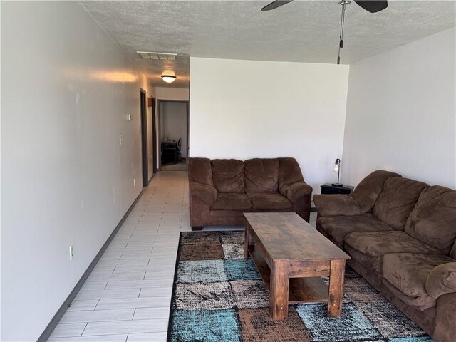 102 W Adams St, Toledo, IL 62468 - living area featuring ceiling fan, a textured ceiling, and baseboards
