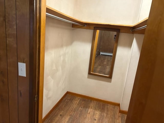 spacious closet with hardwood / wood-style floors and a baseboard radiator