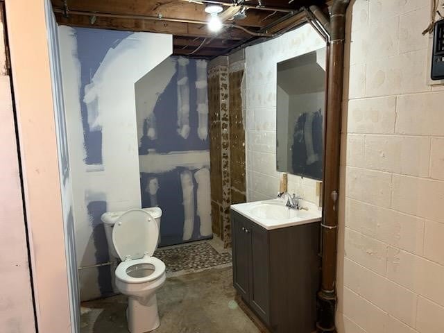 bathroom with vanity, concrete flooring, and toilet