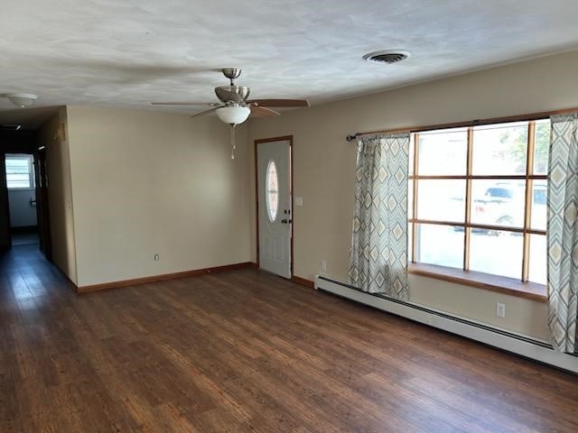 unfurnished room featuring a wealth of natural light, ceiling fan, and a baseboard radiator