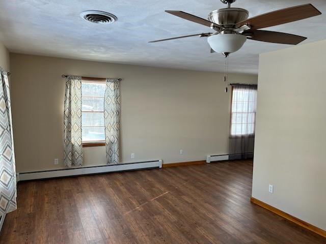 empty room with dark hardwood / wood-style flooring, a baseboard radiator, and ceiling fan