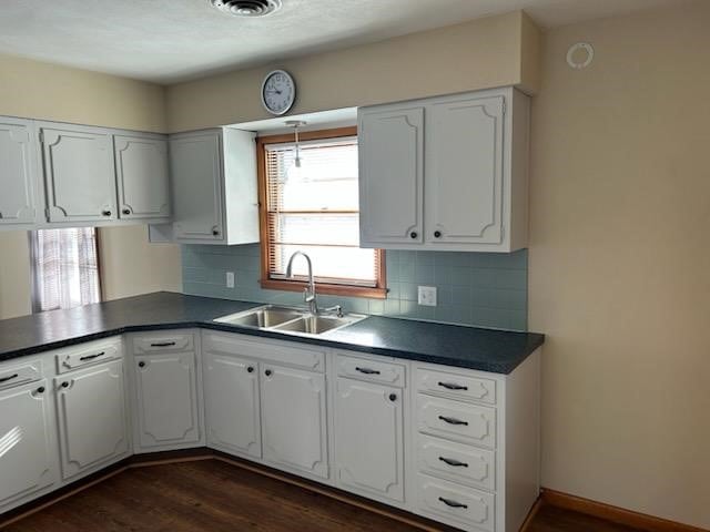 kitchen with plenty of natural light, dark hardwood / wood-style flooring, white cabinetry, and sink