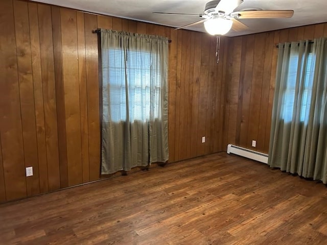 unfurnished room featuring wooden walls and a baseboard heating unit