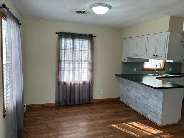 kitchen featuring dark hardwood / wood-style flooring, white cabinetry, sink, and a wealth of natural light