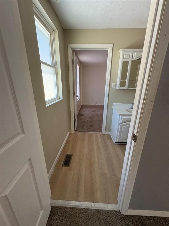 hall with visible vents and baseboards