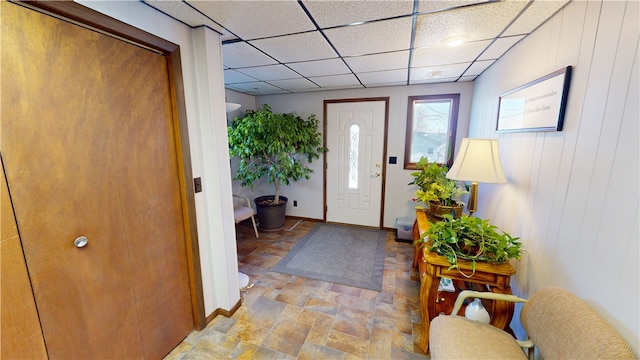 foyer entrance featuring a paneled ceiling and wood walls