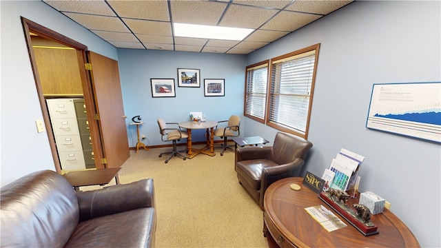 carpeted living room featuring a drop ceiling