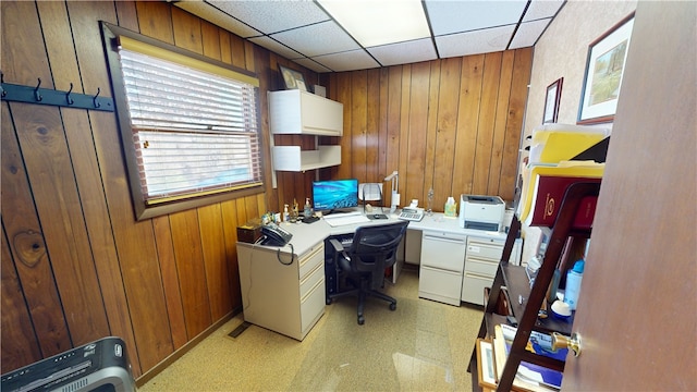 home office featuring a drop ceiling and wooden walls