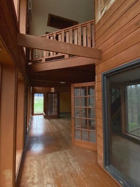 interior space featuring wood walls, a towering ceiling, and wood finished floors