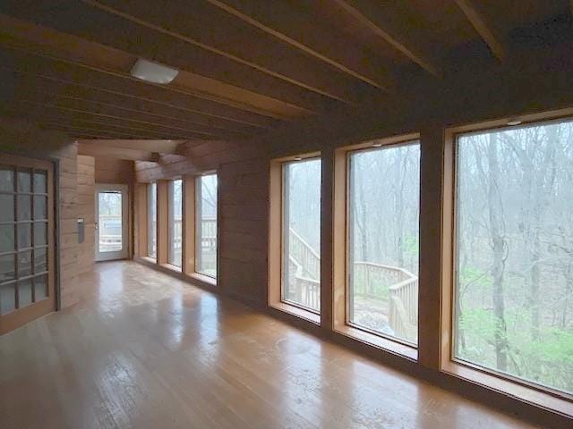 unfurnished sunroom featuring plenty of natural light and wood finished floors