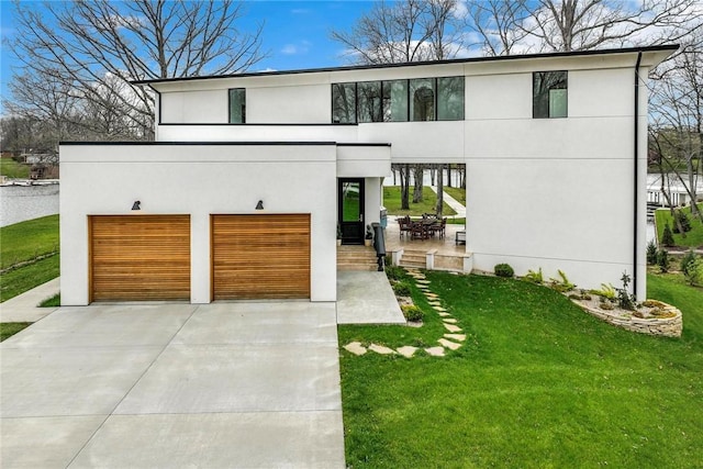 9219 E Best Ct, Effingham, IL 62401 - contemporary home with driveway, a front lawn, a garage, and stucco siding