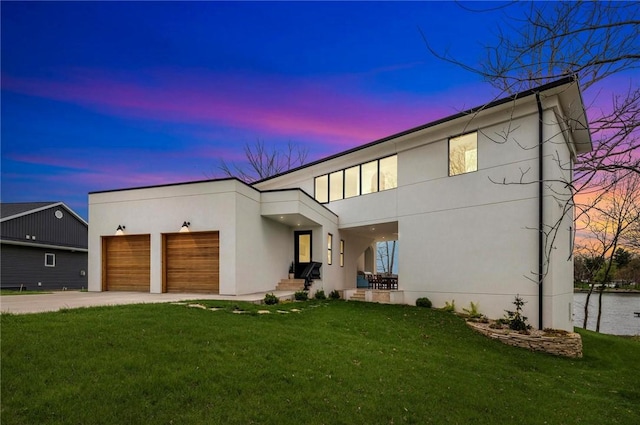 9219 E Best Ct, Effingham, IL 62401 - modern home featuring stucco siding, concrete driveway, a lawn, and an attached garage