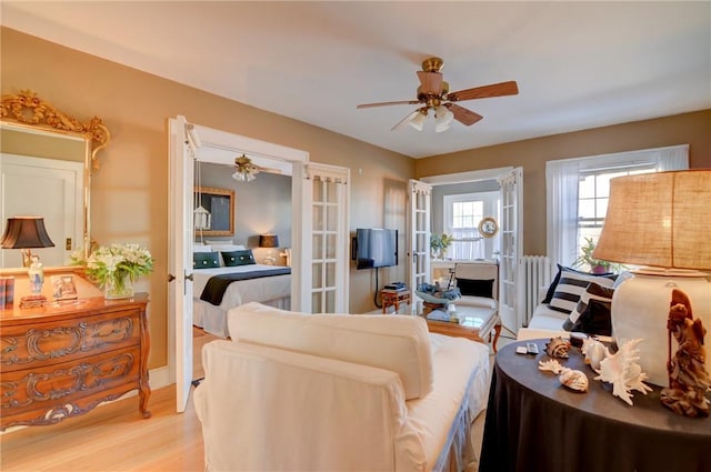 living room featuring french doors, light hardwood / wood-style flooring, and ceiling fan