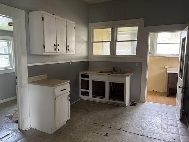 kitchen featuring a sink, white cabinetry, and light countertops