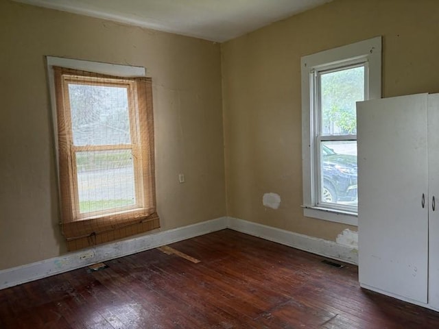 spare room with hardwood / wood-style floors and baseboards
