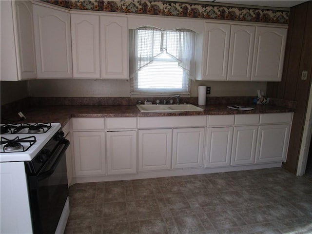 136 Macarthur Blvd, Pana, IL 62557 - kitchen with range with gas cooktop, white cabinetry, and dark countertops