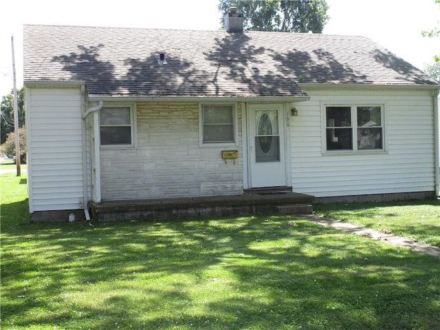 136 Macarthur Blvd, Pana, IL 62557 - view of front facade with a chimney, a front yard, a shingled roof, and entry steps