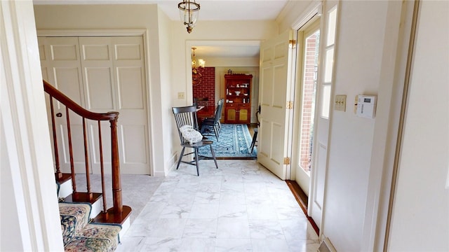 foyer entrance with marble finish floor, baseboards, an inviting chandelier, and stairway