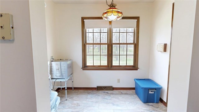 empty room featuring baseboards, visible vents, and a healthy amount of sunlight