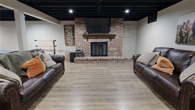 living area featuring recessed lighting, wood finished floors, and a fireplace