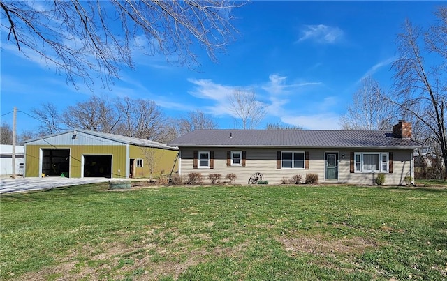 ranch-style house with a front yard, an outbuilding, a chimney, a garage, and metal roof