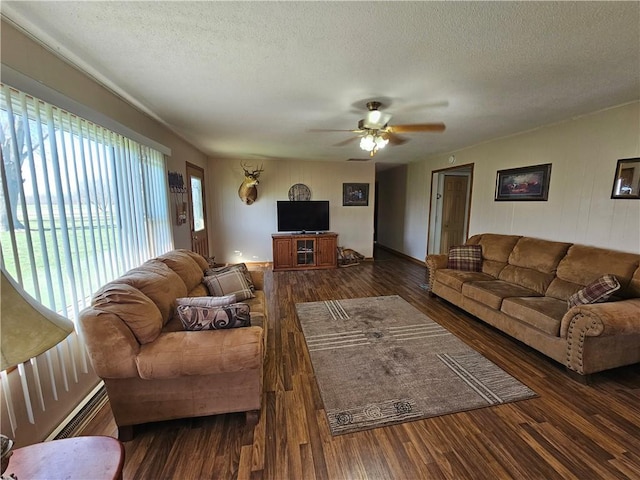 living area with a baseboard radiator, a textured ceiling, wood finished floors, and a ceiling fan