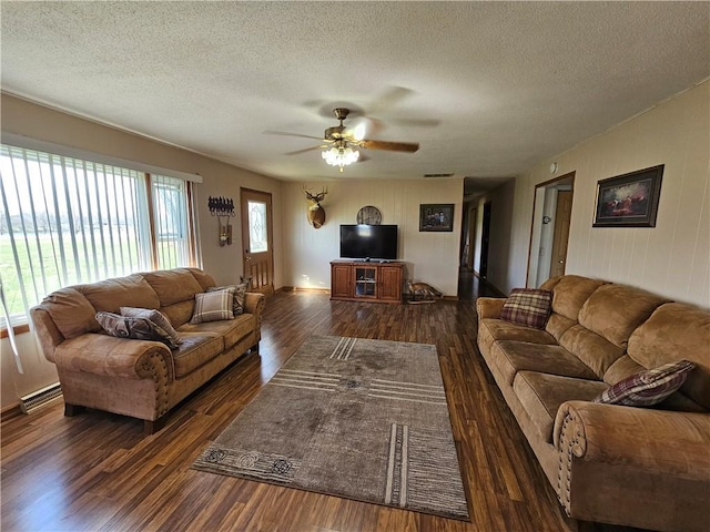 living area with visible vents, a textured ceiling, a ceiling fan, and wood finished floors