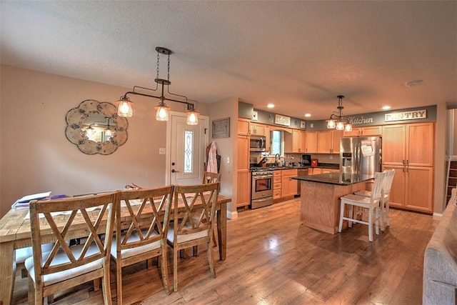 dining room with a textured ceiling and light wood-type flooring