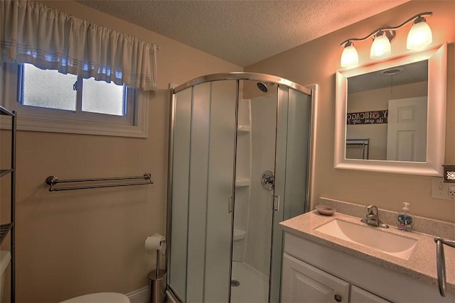 bathroom featuring vanity, a textured ceiling, and a shower with shower door