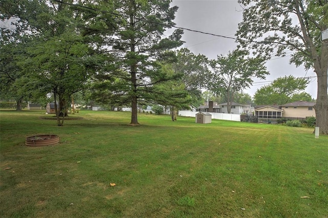 view of yard with a storage shed and an outdoor fire pit