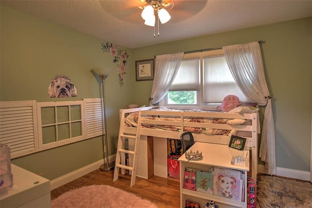 bedroom with ceiling fan, hardwood / wood-style floors, and a textured ceiling