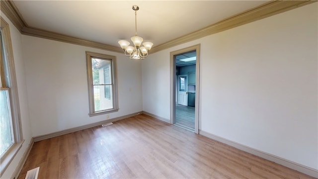 1204 N Franklin St, Danville, IL 61832 - empty room featuring crown molding, a chandelier, light wood-style flooring, and baseboards